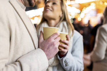 Glückliches Paar mit Kaffeetasse auf dem Weihnachtsmarkt - WPEF07366