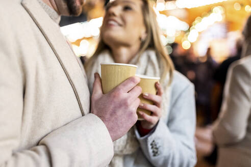Happy couple with coffee cup at Christmas market  - WPEF07366