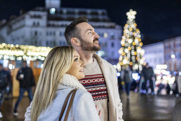 Happy couple standing at Christmas market - WPEF07367