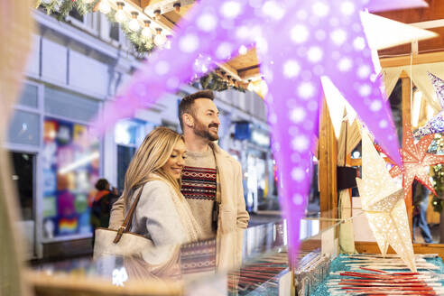 Glückliches Paar beim Einkaufen auf dem Weihnachtsmarkt - WPEF07375