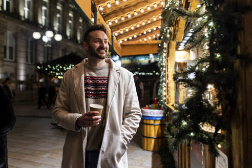 Mann mit Kaffeetasse auf dem Weihnachtsmarkt - WPEF07393