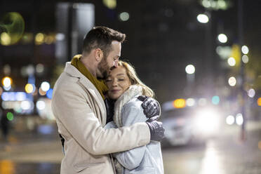 Lächelnde Frau umarmt Mann auf der Straße - WPEF07404