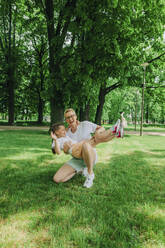 Mutter trägt Tochter und hockt im Park - VSNF01022