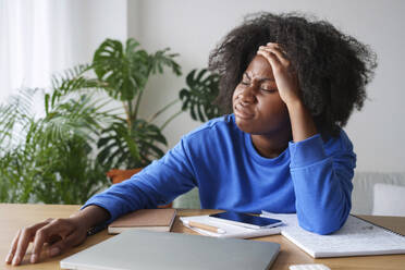 Frustrierte Afro-Geschäftsfrau mit Kopf in der Hand am Schreibtisch - AAZF00702