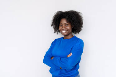 Young Afro woman with arms crossed standing against white background - AAZF00703