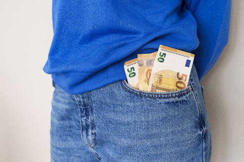 Frau mit Papiergeld in der Jeanstasche - AAZF00716