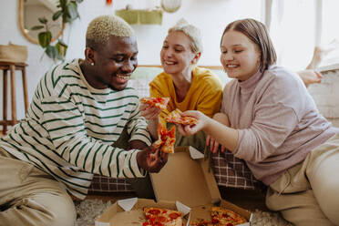Glückliche junge Freunde beim Pizzaessen zu Hause - MDOF01301