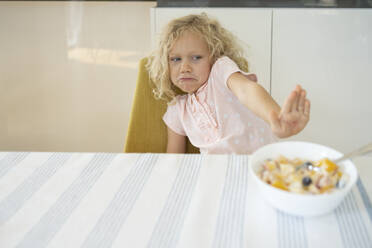 Girl refusing breakfast at table - SVKF01430