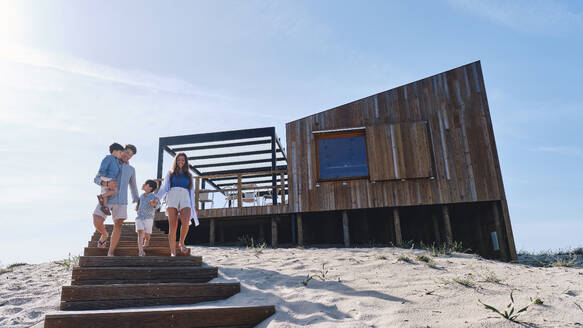 Familie, die sich auf einer Treppe am Strand niederlässt - ASGF03706