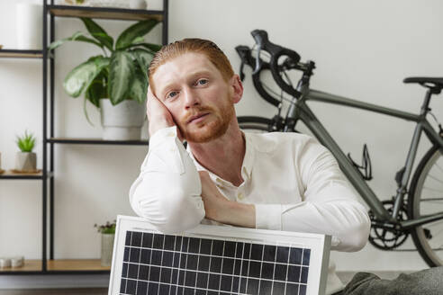 Geschäftsmann lehnt sich im Büro an ein Solarpanel - OSF01636