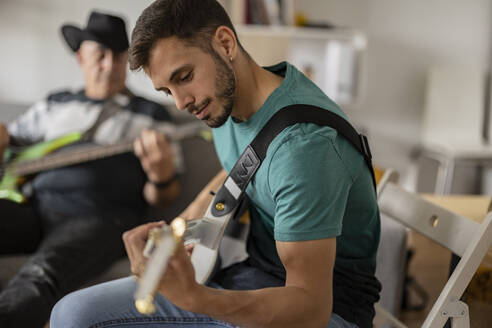 Musiker mit E-Gitarren beim Üben zu Hause - JCCMF10457