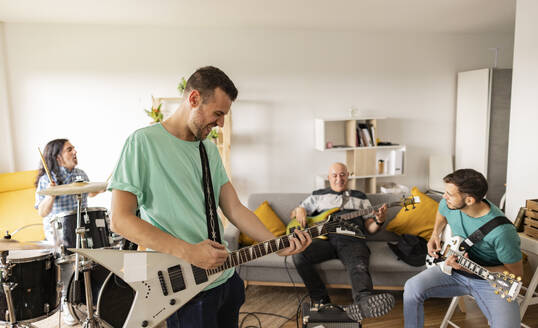 Rockmusiker beim gemeinsamen Üben mit Musikinstrumenten zu Hause - JCCMF10466