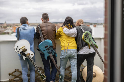 Zusammenstehende Rockmusiker mit E-Gitarren auf einem Dach - JCCMF10490