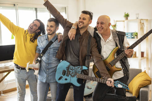Glückliche Rockmusiker mit Gitarren, die zu Hause Spaß haben - JCCMF10493