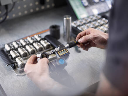 Engineer examining machine part at factory - CVF02412