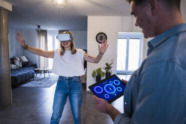 Mann mit Tablet-PC und Frau mit Virtual-Reality-Simulator - UUF28828