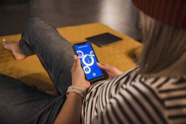 Young woman operating mobile app at home - UUF28872