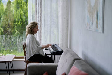 Senior woman playing piano at home - ANNF00278