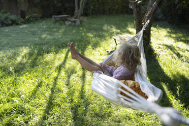 Mädchen schwingt auf Hängematte im Garten - SVKF01433