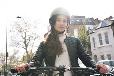 Aufmerksamer Zusteller mit Fahrrad an einem sonnigen Tag - AMWF01395