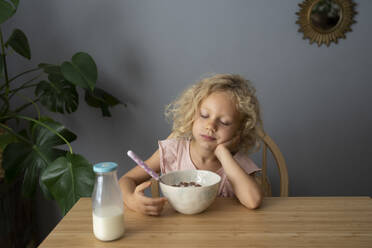 Girl with bowl of cereals sleeping at table - SVKF01463