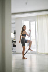 Smiling woman exercising with resistance band - ANNF00303