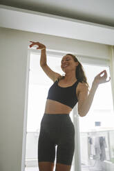 Happy woman gesturing and dancing at home - ANNF00320