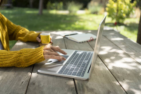 Hände eines Freiberuflers mit Laptop am Tisch - SVKF01466