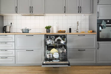 Dishes inside dishwasher in kitchen at home - ALKF00332