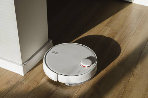 Robot vacuum cleaner on hardwood floor at home - ALKF00340