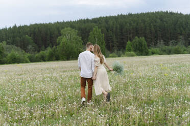Junges Paar küsst sich auf einem Wildblumenfeld - SEAF01998