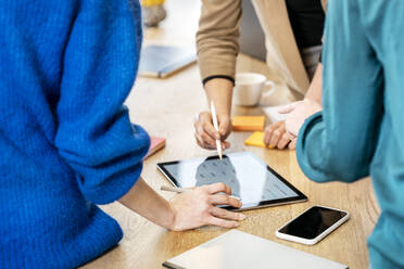 Geschäftskollegen bei einer Diskussion über einen Tablet-PC auf dem Tisch - PESF04033