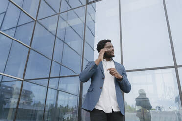 Young businessman standing in front of office building - OSF01690