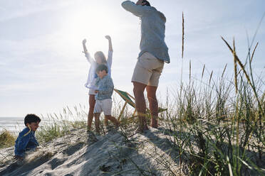 Parents enjoying with children at beach on sunny day - ASGF03750