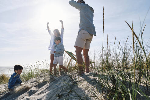 Eltern genießen mit Kindern am Strand an einem sonnigen Tag - ASGF03750