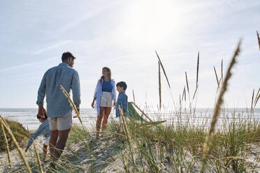 Eltern und Kinder verbringen ihre Freizeit am Strand an einem sonnigen Tag - ASGF03752