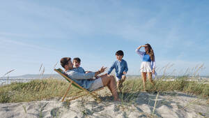 Family spending leisure time at beach on sunny day - ASGF03768