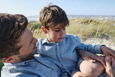 Father carrying son relaxing at beach - ASGF03769