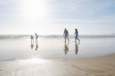 Familie genießt zusammen am Strand an einem sonnigen Tag - ASGF03799