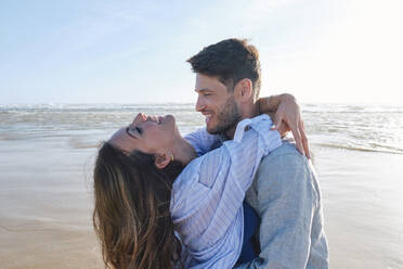 Happy couple embracing each other at beach - ASGF03808