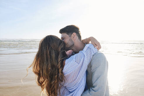 Romantic couple embracing and kissing at beach - ASGF03809