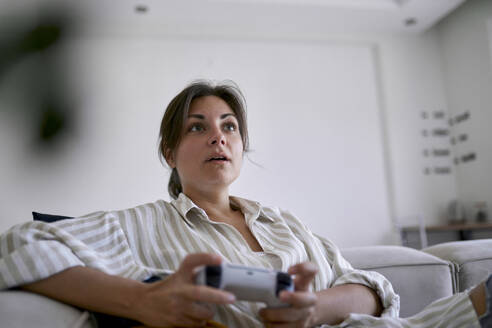 Überrascht Frau spielt Videospiel zu Hause - ANNF00338