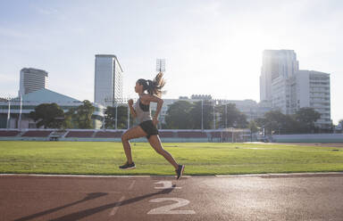 Austria, Teenage girl running on track, portrait stock photo