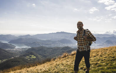 Glücklicher reifer Wanderer erkundet den Berg an einem sonnigen Tag - UUF28884