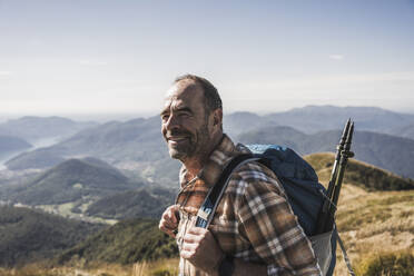 Lächelnder Wanderer mit Rucksack an einem sonnigen Tag - UUF28892