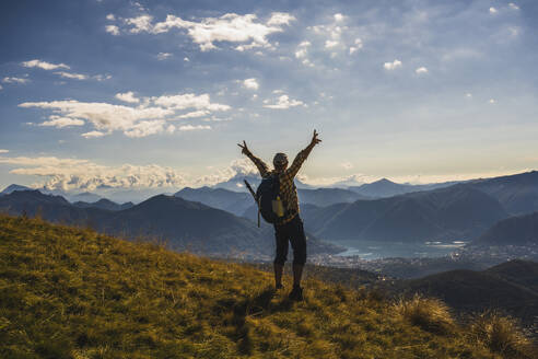 Hiker making victory sign standing on mountain - UUF28902