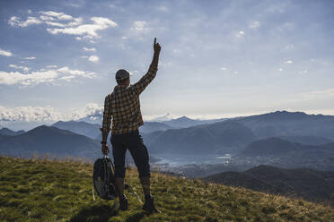 Hiker gesturing standing on mountain - UUF28905