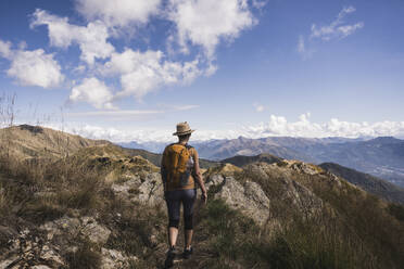 Hiker with backpack walking in rocky mountains - UUF28913