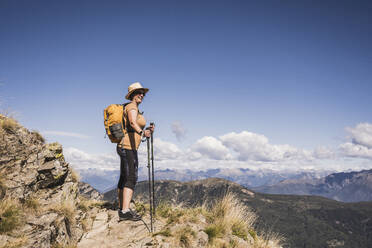 Woman exploring nature standing on mountain - UUF28919