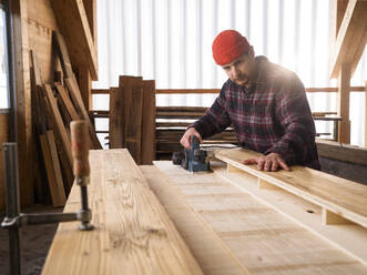 Carpenter working with hand tool at workshop - CVF02438